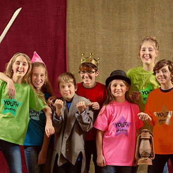 Cheerful group of child actors stand together and smile at the camera